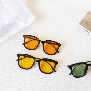Flat lay of retro square sunglasses with orange, yellow, and green translucent lenses
