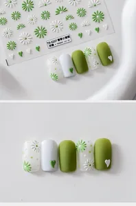 Detailed macro of 5D floral embossed nail stickers with daisy and heart motifs in green