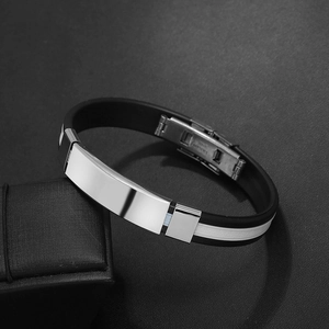 Close-up of black silicone men's bracelet with polished stainless steel clasp on a gift box
