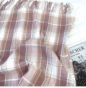 Detail of plaid scarf texture with soft tassels and earthy checkered pattern