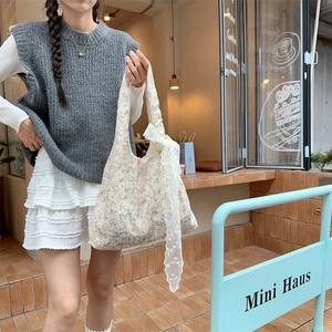 Detail of floral canvas tote bag featuring delicate lace bow and pastoral print design
