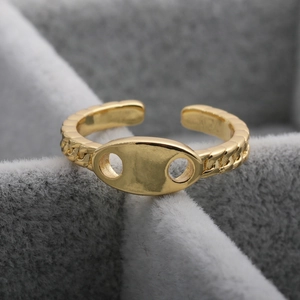 Detailed close-up of an 18K gold-plated adjustable pig nose ring on grey velvet