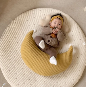 Macro detail of ginger quilted cotton moon nursing pillow with baby on star mat