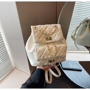 Detailed macro of cream quilted PU leather backpack with gold chain and twist locks