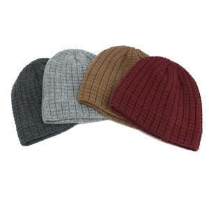 Close-up of ribbed knit beanies in dark grey, light grey, camel, and burgundy shades