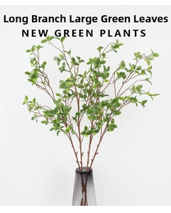 Close-up of artificial Milan leaf branches with green foliage in a dark glass vase