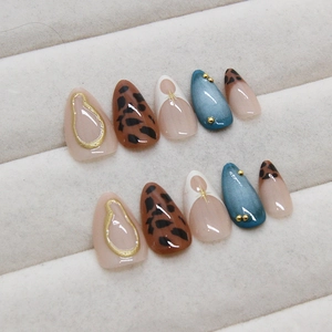 Leopard print press-on nails with blue pearl finish and gold stud accents