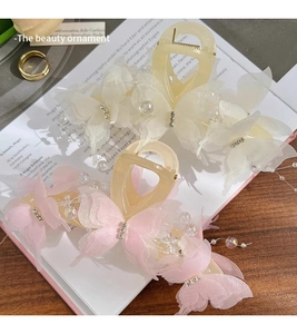 Detailed view of butterfly hair claws with mesh ribbons, pearls and rhinestones