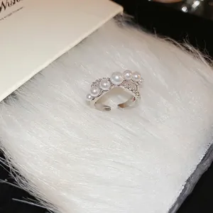 French style silver criss-cross ring with graduated pearls and zircon accents