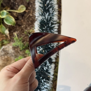 Detail of an 8cm triangular claw clip with amber tortoiseshell texture and resin finish