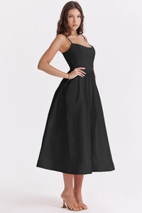 Detail of the backless design on a black minimalist midi dress with thin straps