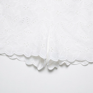 Pantaloncini in pizzo bianco con ricami floreali delicati e bordo ondulato a smerlo