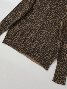Close-up detail of leopard print knit cardigan showing ribbed cuffs and hem texture