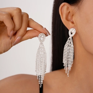 Elegant long tassel rhinestone drop earrings with silver needles on an Asian model