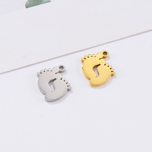 Close-up of baby footprint charms in silver and gold stainless steel for DIY jewelry