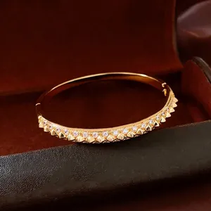 Luxury 18K gold plated bangle featuring conical studs and inlaid cubic zirconia stones