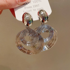 Macro view of multi-layer spiral hoop earrings in bright silver finish for women