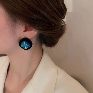 Gros plan sur les boucles d'oreilles rétro carrées en cristal sarcelle et velours noir