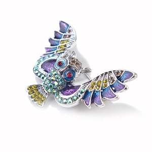 Détail de la broche hibou avec ailes en émail coloré et strass brillants incrustés