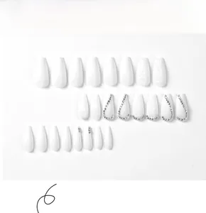 Details von weißen matten Press-on Nails mit Herzmustern und Strass-Akzenten