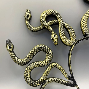 Detailed view of Medusa snake headband showing golden textures and hair comb teeth