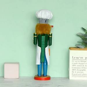 Rear view of chef nutcracker figure with green jacket and blue pants on red base