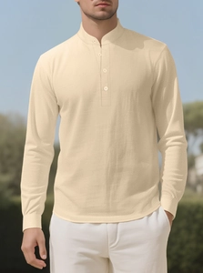 Detailed close-up of textured cotton linen fabric and button placket on beige shirt