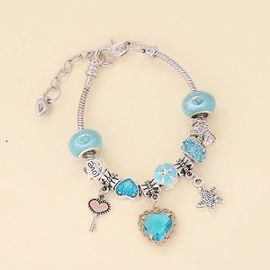 Detail of light blue crystal heart charms and starfish pendant on silver-plated bracelet