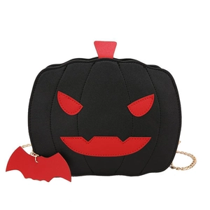 Detail of pumpkin crossbody bag with red face patchwork and bat charm detail
