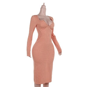 Dettaglio della trama in maglia a costine arancio-rosa e bottoni sul vestito scollo a V