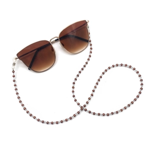 Close-up of retro beaded eyeglass chain with brown beads and tea gradient sunglasses