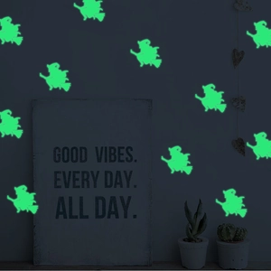 Close-up of glowing fluorescent green witch on broom Halloween wall decals in the dark