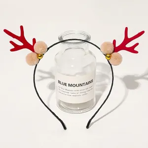 Detail of Christmas headband with red reindeer antlers, plush balls and golden bells