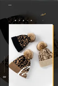 Détail des bonnets en tricot imprimé léopard avec de grands pompons en fausse fourrure