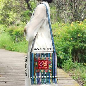 Close-up of ethnic embroidery bag with tassels and wooden beads in outdoor setting