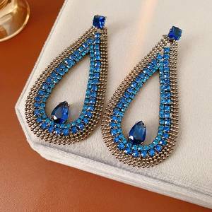 Detailed macro of blue teardrop-shaped zircon earrings with intricate hollow vintage design