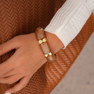 Detail of amber resin stretch bracelet with golden glitter and metallic spacer beads