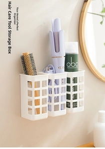 Close-up of wall-mounted white mesh storage baskets for curling irons and hair tools