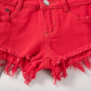 Nahaufnahme der roten Jeans-Shorts mit Metallknopf, Nieten und ausgefranstem Saum