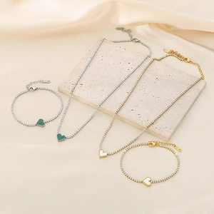 Detail of stainless steel tennis chain jewelry set with green and white heart pendants