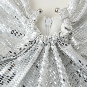 Dettaglio dello scollo di un abito da festa con paillettes argento e cerniera in metallo