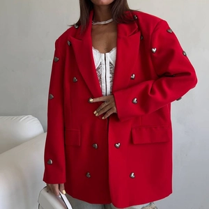 Detail of red oversized blazer featuring heart-shaped metal buttons and stylish fit