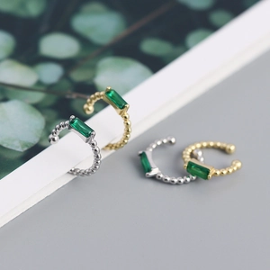 Macro shot of gold and silver S925 beaded ear cuffs with emerald zircon stones