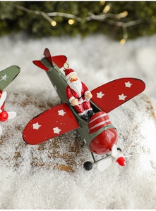 Detail of vintage metal airplane Christmas ornament with Santa Claus in faux snow