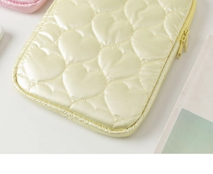 Detail of heart-quilted texture and dual zippers on a light yellow laptop sleeve case
