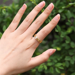 Detail of 18k gold plated ring with a square zircon gemstone on a finger