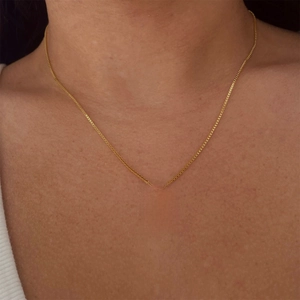 Minimalist gold cross necklace with white zircon crystals on a delicate box chain