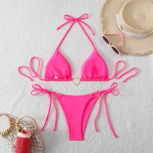 Neon pink bikini with golden heart metal rings and side-tie bottoms on plush carpet