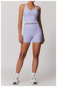 Dettaglio del set da yoga viola chiaro con crop top sportivo e pantaloncini ciclisti a vita alta