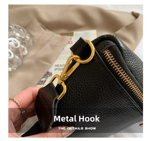 Close-up of golden metal hook and hardware on black lychee grain leather waist bag